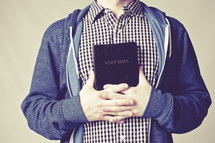 man holding a Bible against his heart
