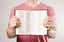 man holding a Bible showing its pages - Psalms 144-200
