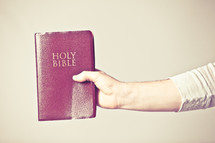 man holding a red covered Bible