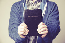 man holding out a Bible