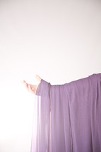 arm draped in purple cloth