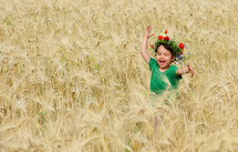happy girl playing in wheat field