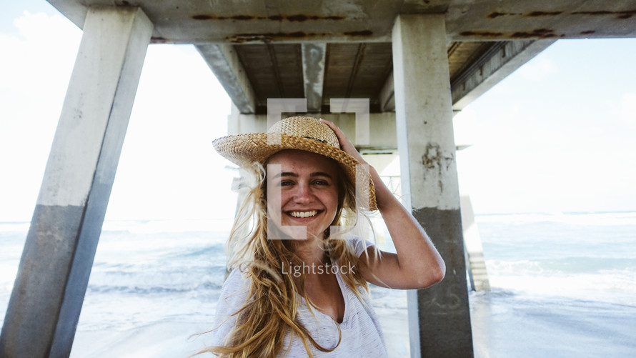 happy woman standing under a pier 