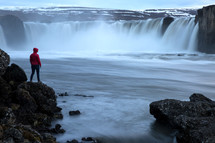 a person watching a waterfall in Iceland 