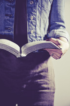 close-up of the pages of a Bible as a woman reads 