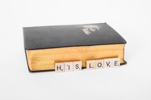 A Bible and the words his love in scrabble pieces. 