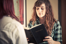 young women reading and discussing a Bible at a Bible study
