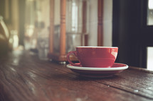 red mug on a wood table 
