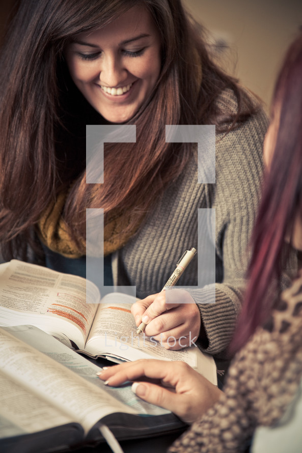 young woman underlining scripture at a Bible study