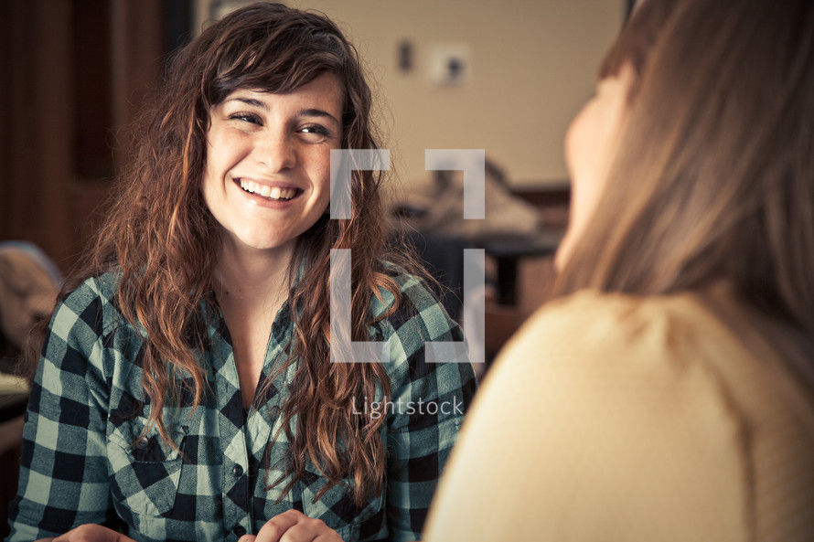 smiling young women discussing scripture at a Bible study