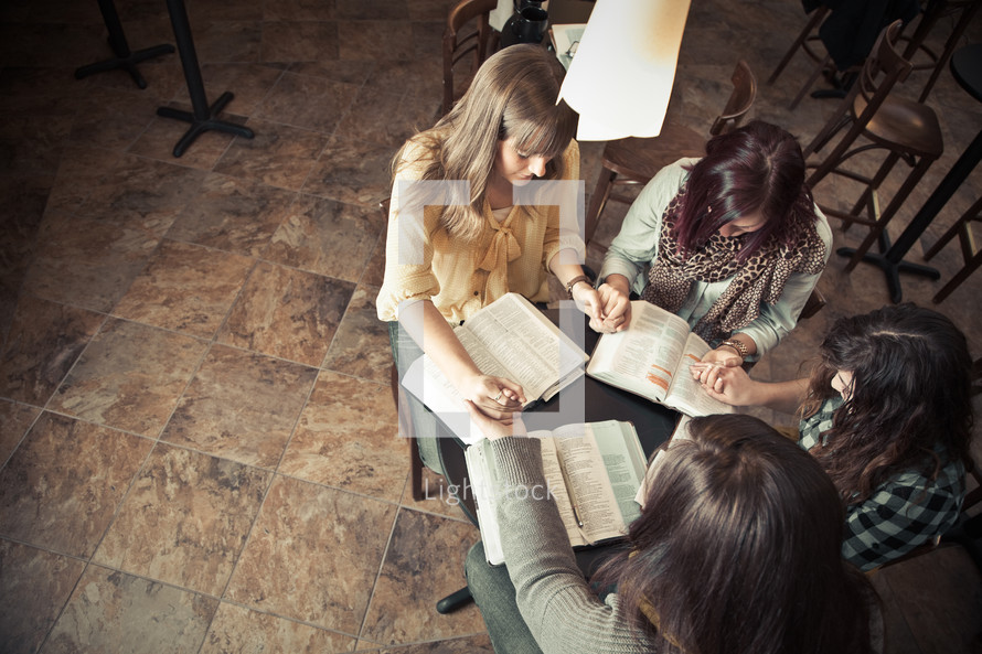 Women praying at a Bible study.