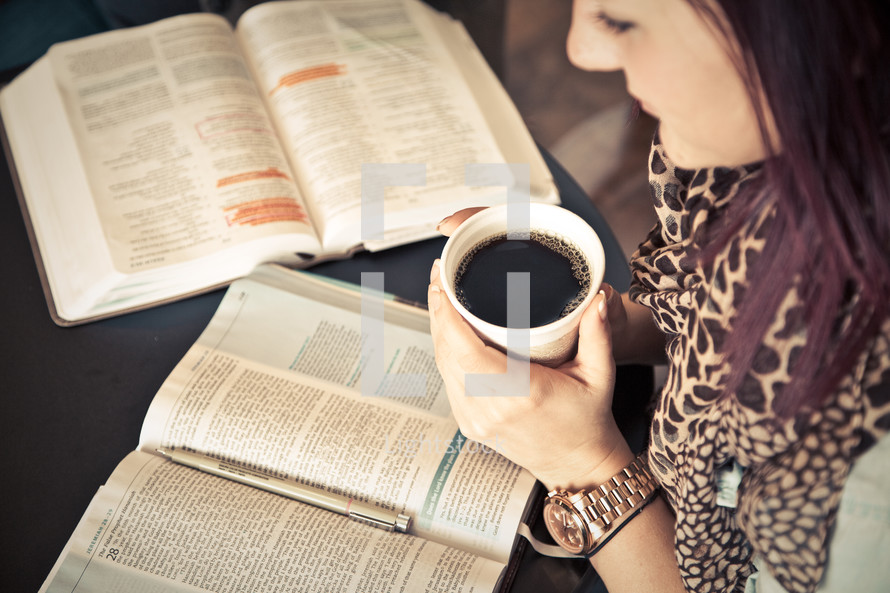 woman holding a cup of coffee and reading a Bible at a Bible study