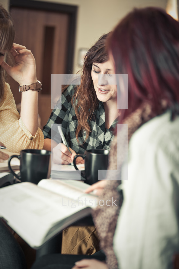 Three women drinking coffee during a Bible study.