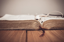 earbuds on the pages of an open Bible 