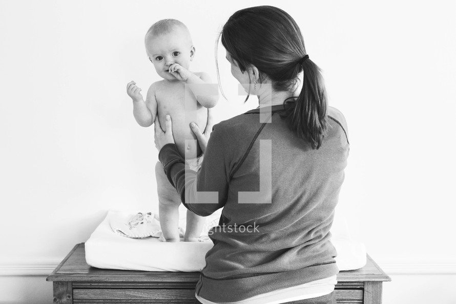 a mother and infant at a changing table 