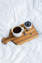 coffee and blueberries on a cutting board 