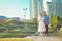 a couple standing in front of a city 