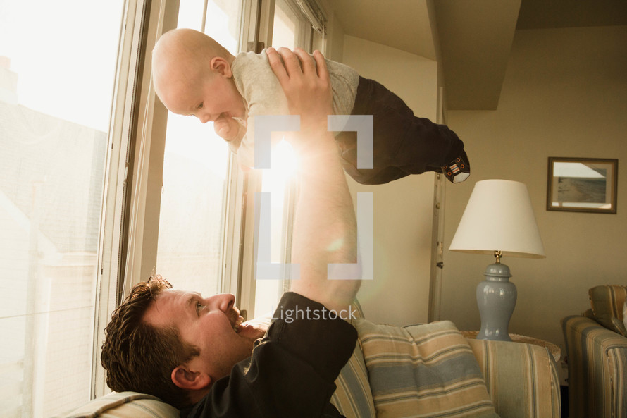 man holding up his infant son 