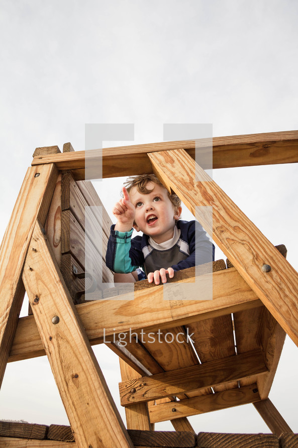 toddler boy on playground equipment 