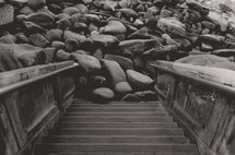 steps leading down to rocks at a shore 