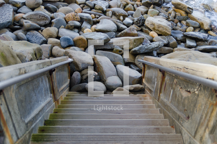 steps leading to rocks at a shore