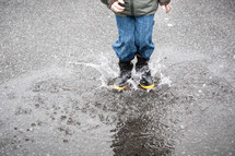 a child splashing in a puddle 
