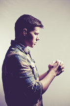 man in prayer against a white background