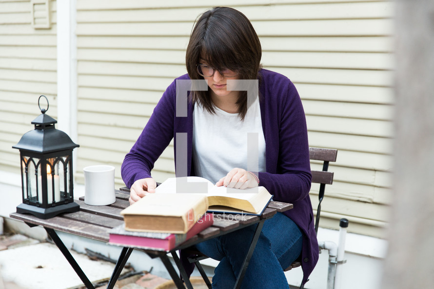 A woman studies at a small table.
