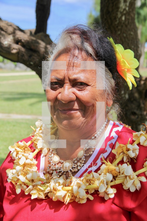 a woman wearing a lei with flowers in her hair 