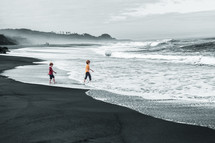 boys walking in the tide