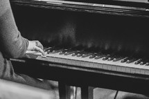 Close up of a woman playing the piano for a church worship service in black and white.