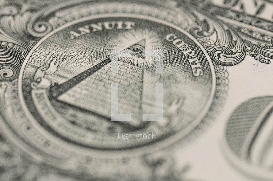 Closeup of the back of a dollar bill showing the Pyramid, eye emblem