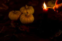 lighting a candle with pumpkins