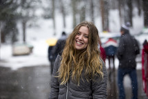 a smiling woman in falling snow 