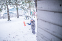 a boy child shoveling snow 