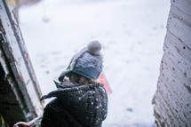 a boy child shoveling snow in a doorway 