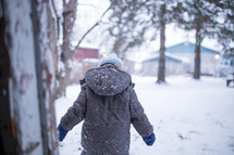a boy child playing in snow 