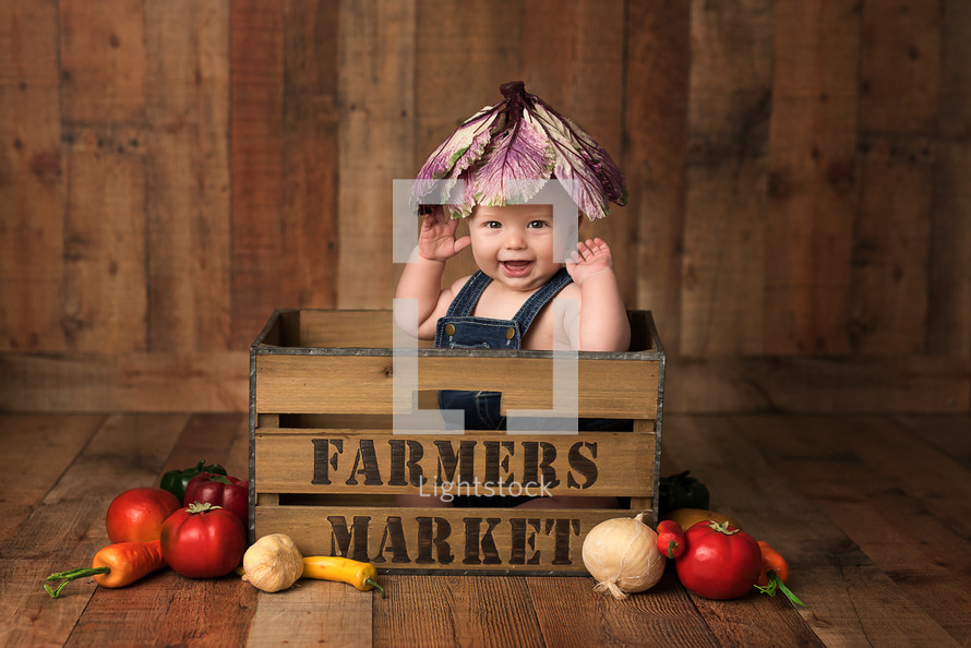infant on a farmers market crate 