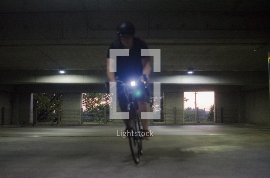 man riding a bicycle in a parking garage 