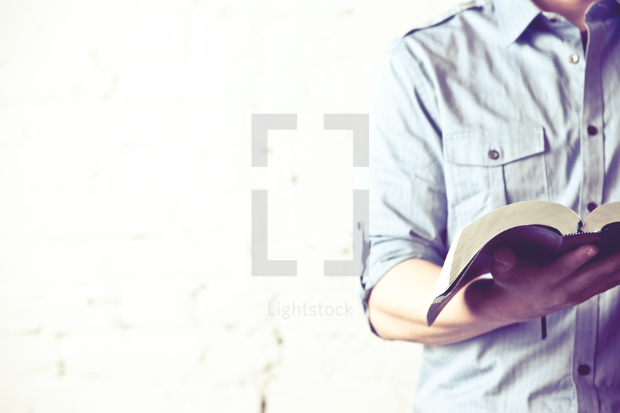 man holding an open Bible