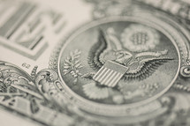 Closeup of a dollar bill showing eagle emblem