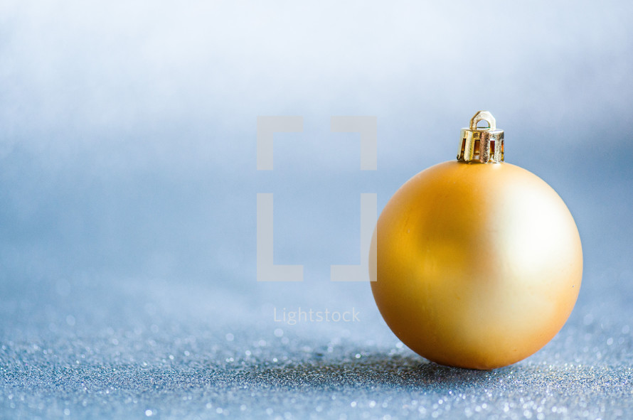 Yellow Christmas orb on a glittering backdrop