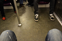 passengers feet on a subway train 