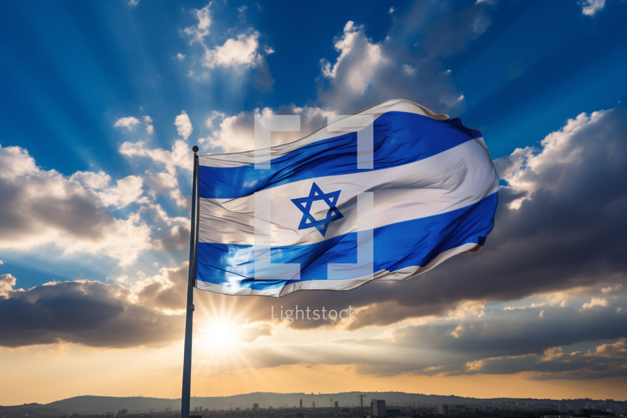 The flag of the nation Israel blowing the wind at dawn with the sun setting on the horizon. 