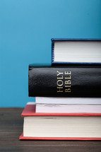 A Bible in a stack of books.
