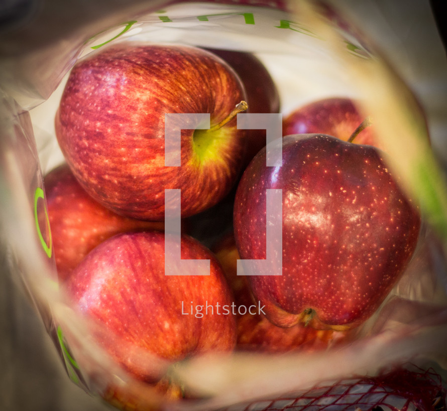 A bag of fresh red apples.
