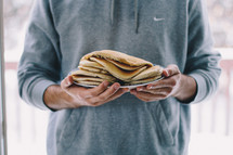 a man holding a plate full of pancakes 