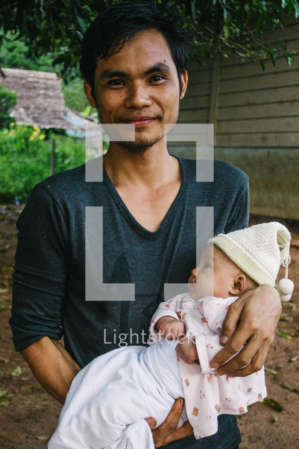 a father holding his newborn daughter 