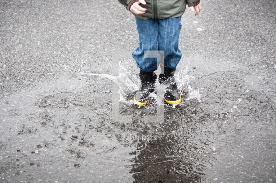 a child splashing in a puddle 