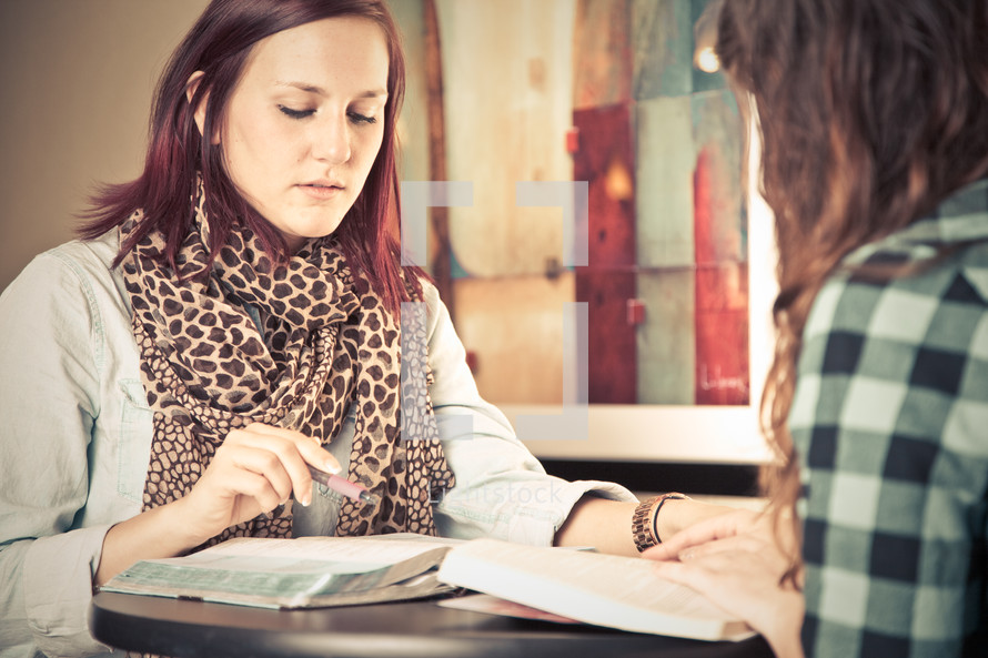 young women reading and discussing the Bible at a Bible study